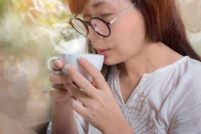 Close-up of young woman holding eyeglasses