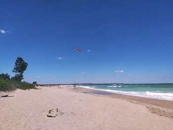 Scenic view of beach against clear blue sky