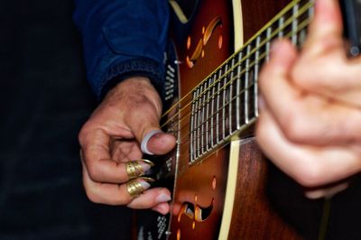 Midsection of man playing guitar