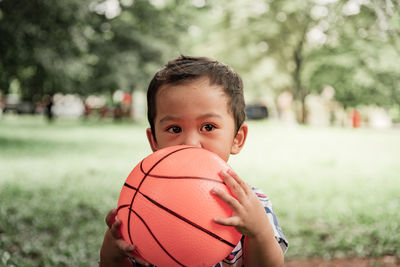 Portrait of boy playing basketball