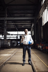 Full length portrait of young man standing in bus