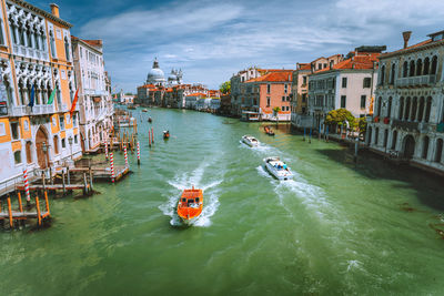 Boats in canal amidst buildings in city