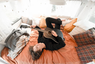 High angle view of woman sitting on bed at home