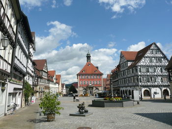 Buildings by road against sky in city