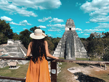 Rear view of woman in temple against sky