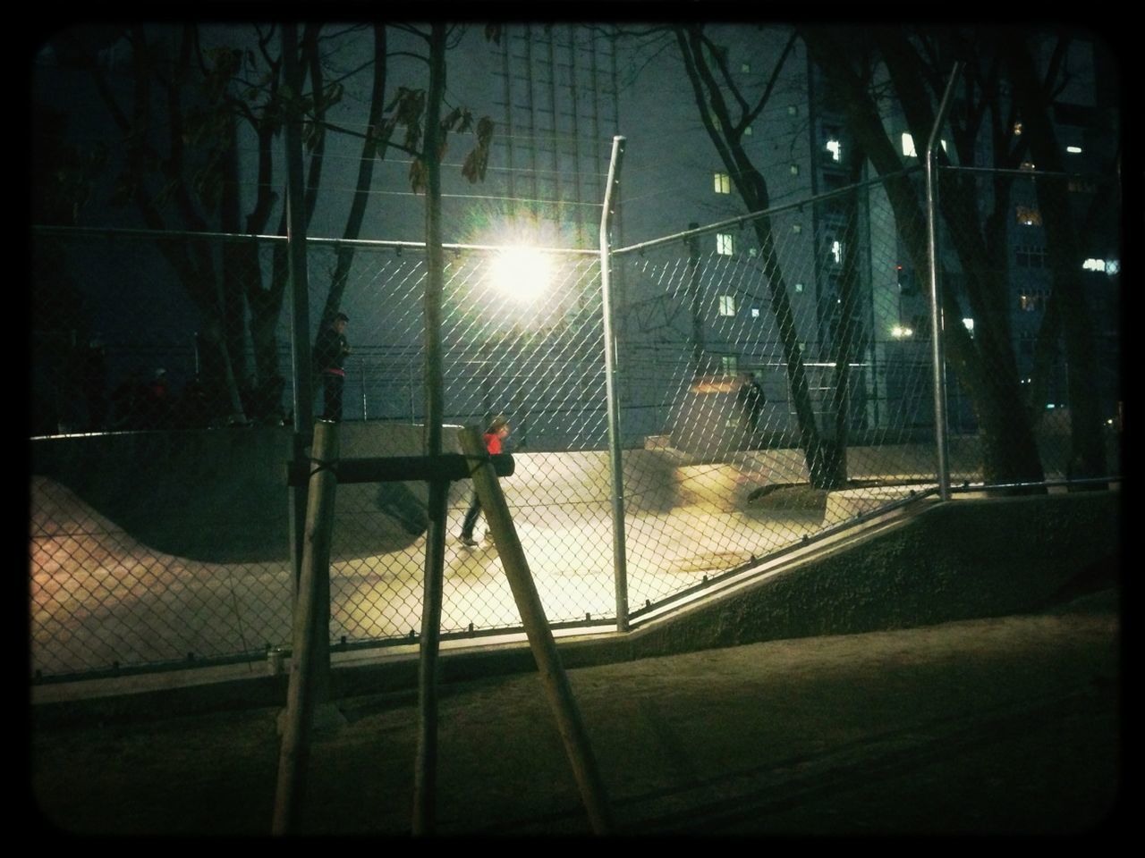 transfer print, built structure, architecture, auto post production filter, transportation, glass - material, building exterior, window, fence, tree, sunlight, night, metal, railing, protection, chainlink fence, safety, no people, illuminated, lens flare