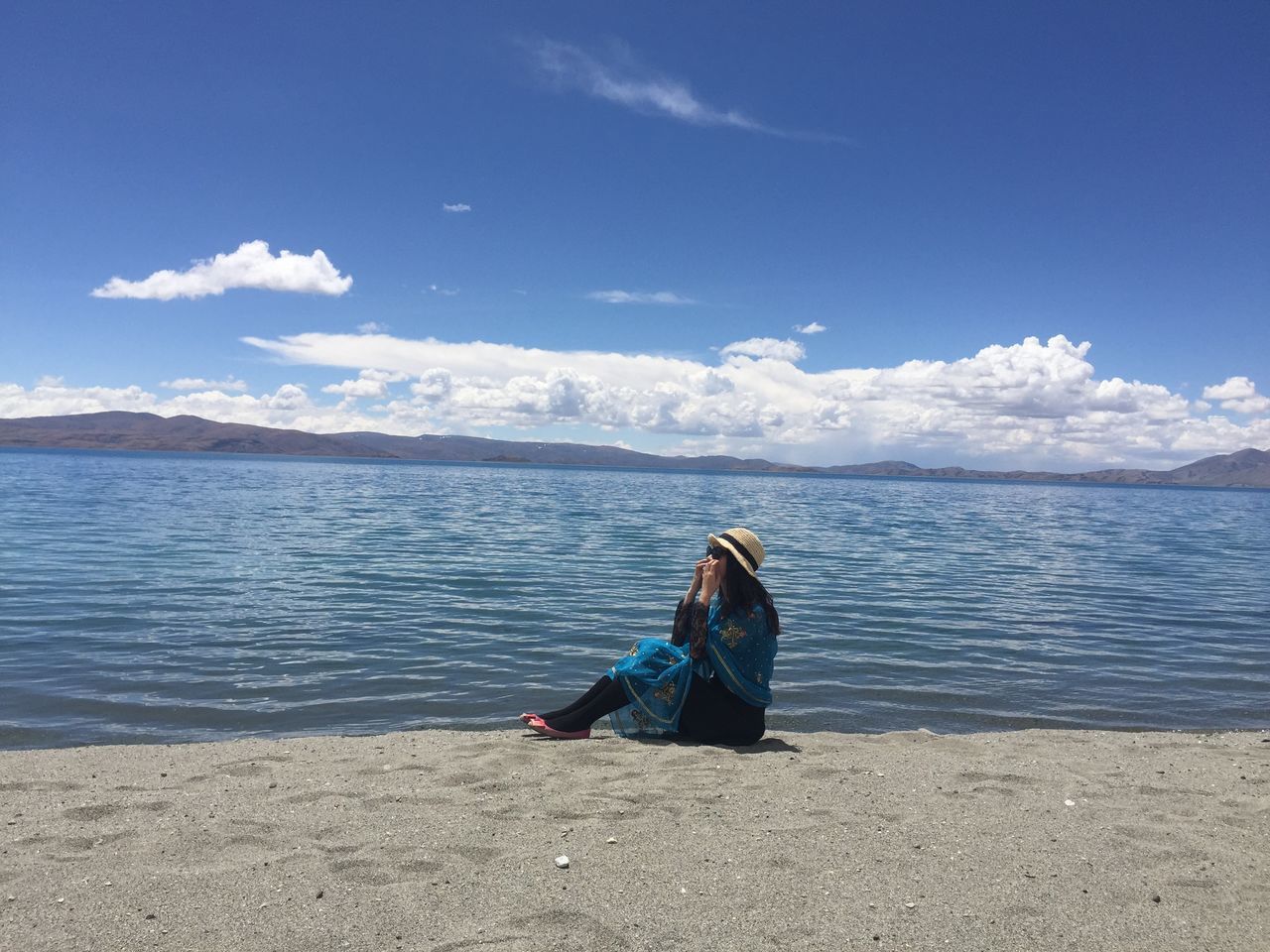 water, sea, rear view, sky, blue, lifestyles, tranquil scene, leisure activity, tranquility, scenics, beauty in nature, relaxation, standing, nature, person, casual clothing, beach, sitting