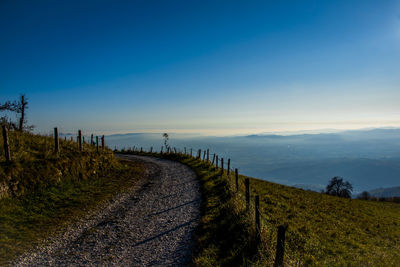 Panoramic shot of footpath on field against sky