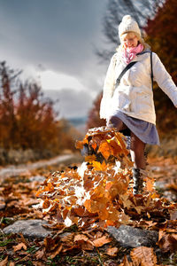 Woman plays with leaves - autumn leaves 