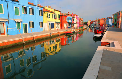 Reflection of buildings in canal against sky