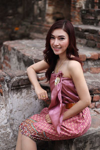 Portrait of a smiling young woman sitting outdoors