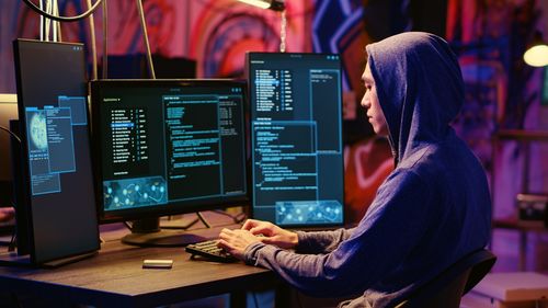 Rear view of woman using laptop in office