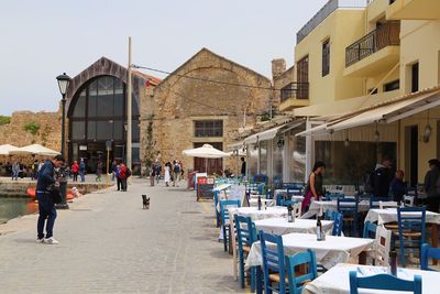 People on street amidst buildings in city