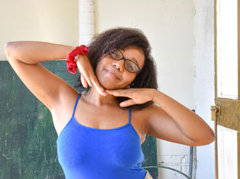 Portrait of smiling woman standing against wall