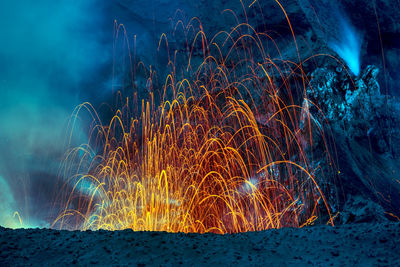 Firework display over sea at night