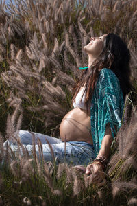 Pregnant young woman in a field looking at the sky