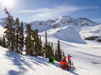 People skiing on snowcapped mountain against sky