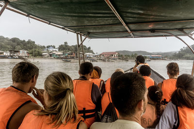 Rear view of people on boat in sea