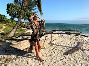 Woman looking away while standing at beach