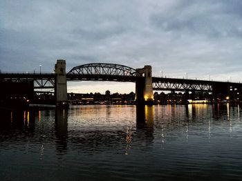 Bridge over river against cloudy sky