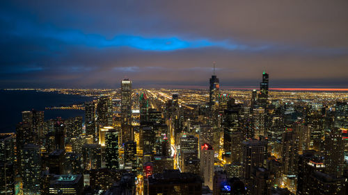 Illuminated cityscape against sky at night