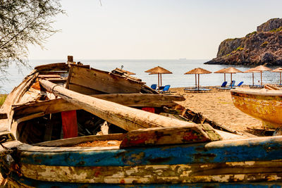 Boats moored on beach against clear sky