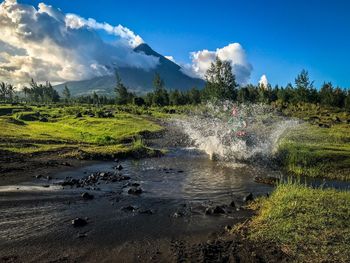 Scenic view of waterfall against sky