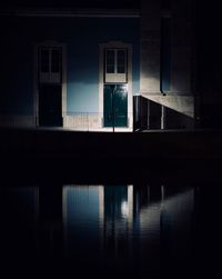 Reflection of silhouette building on window at night