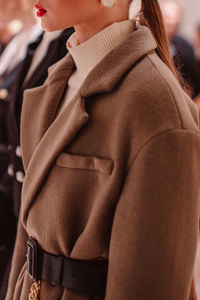 Fashion details of brown autumn winter coat with black belt. fashion model on backstage