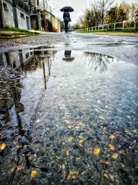 Low section of man walking in puddle