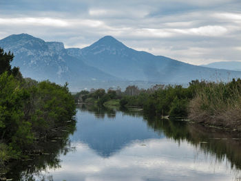 Scenic view of lake by mountains against sky