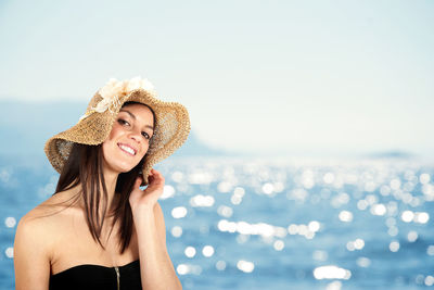 Portrait of smiling young woman against sea