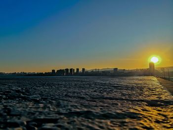 Scenic view of buildings against clear sky during sunset