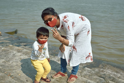 Mother and daughter gesturing near river