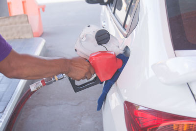 Cropped hand of man refueling car