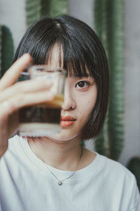 Portrait of young woman holding camera