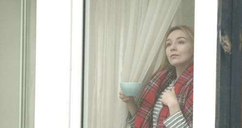 Woman drinking coffee from window