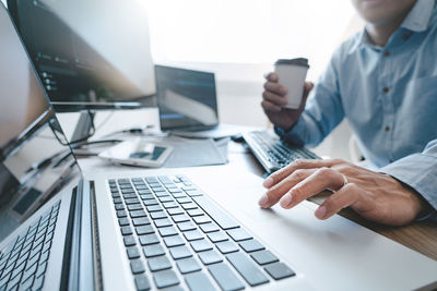 Midsection of man using laptop on table