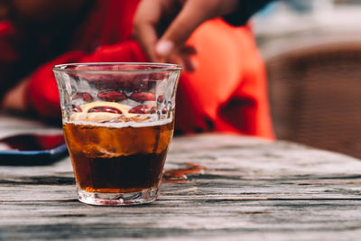 Glass of cola on wooden table at bar