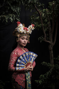 Portrait of woman wearing traditional clothing standing in forest