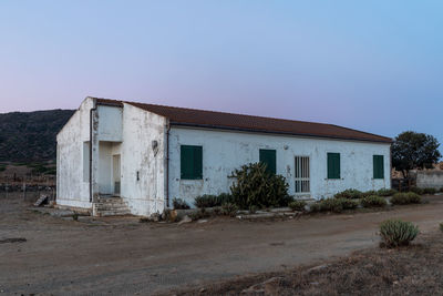 Exterior of old house on field against sky