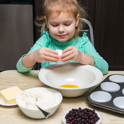 Portrait of cute girl eating food at home