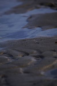 Close-up of wet sand at beach