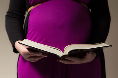 Midsection of woman reading book