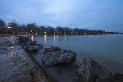 Scenic view of lake against sky at sunset