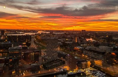 High angle view of illuminated city against sky during sunset