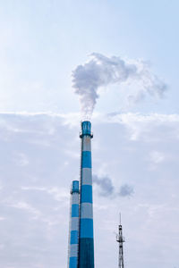 Low angle view of smoke emitting from chimney against sky