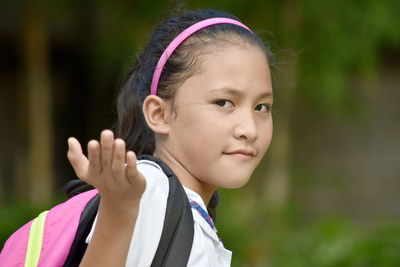 Portrait of cute girl gesturing outdoors