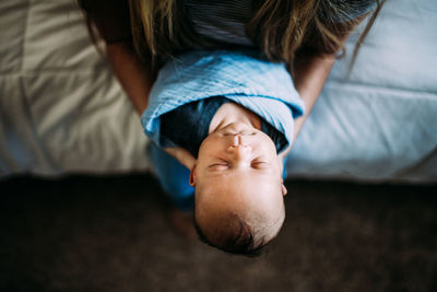 Overhead of mother holding sleeping newborn