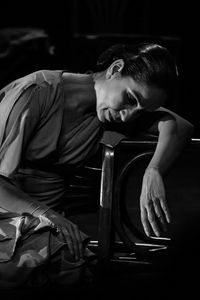 Side view of young man sitting on chair